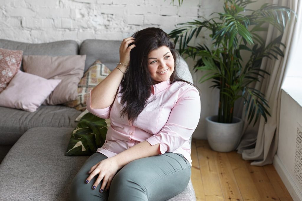 Woman with postpartum hair loss holding clump of shed hair